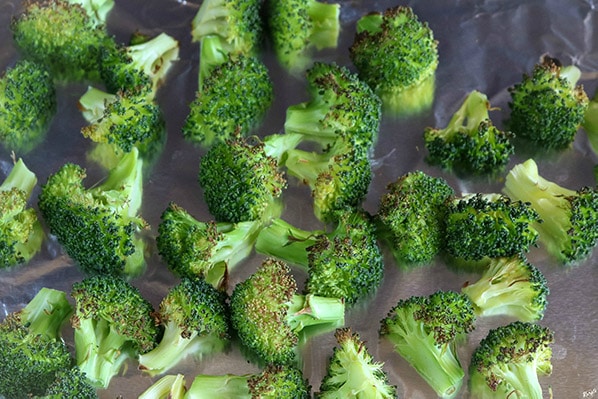 overhead shot of broccoli on baking sheet, after being charred under broiler