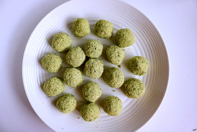 overhead process shot of raw Falafel balls on a white plate