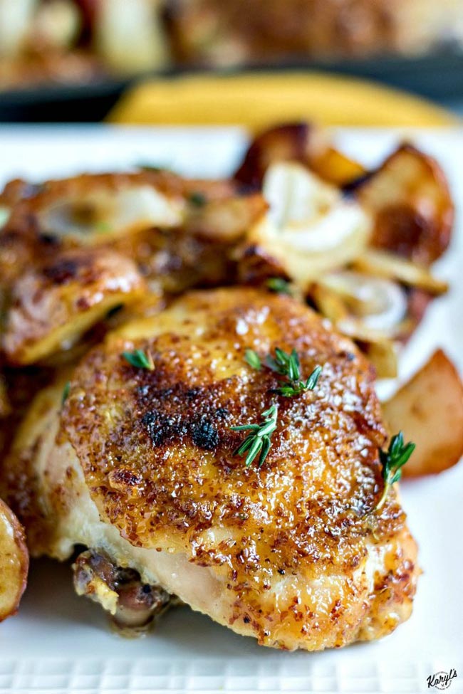 Maple Mustard Garlic Sheet Pan Chicken is an easy dinner that will quickly become a family favorite, and is perfect for entertaining. Coarse mustard, maple syrup and roasted garlic create the mouthwatering glaze for the chicken and vegetables #chicken #chickenthighs #potatoes #onions #sheetpanmeal #maplesyrup #mustard #roastedgarlic #bakedchicken #karylskulinarykrusade