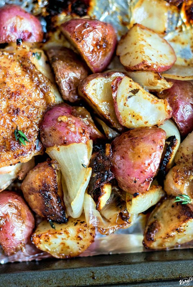 Maple Mustard Garlic Sheet Pan Chicken is an easy dinner that will quickly become a family favorite, and is perfect for entertaining. Coarse mustard, maple syrup and roasted garlic create the mouthwatering glaze for the chicken and vegetables #chicken #chickenthighs #potatoes #onions #sheetpanmeal #maplesyrup #mustard #roastedgarlic #bakedchicken #karylskulinarykrusade