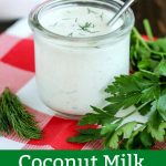 finished Coconut Milk Ranch Dressing in a glass jar with a spoon, on a plaid napkin