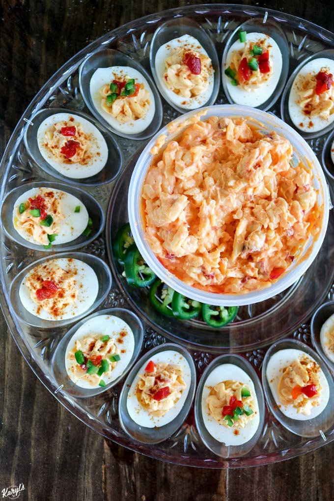 Pimiento Cheese Deviled Eggs will become your new favorite summer party snack! Sweet, tangy and mild Price*s Pimiento Cheese Spread adds a wonderful new flavor dimension to the traditional deviled egg. Finish with diced pimiento peppers plus diced jalapenos for a delicious kick #Ad #pricestradition #pimientiocheesespread #pimientocheese #summerentertaining #deviledeggs 