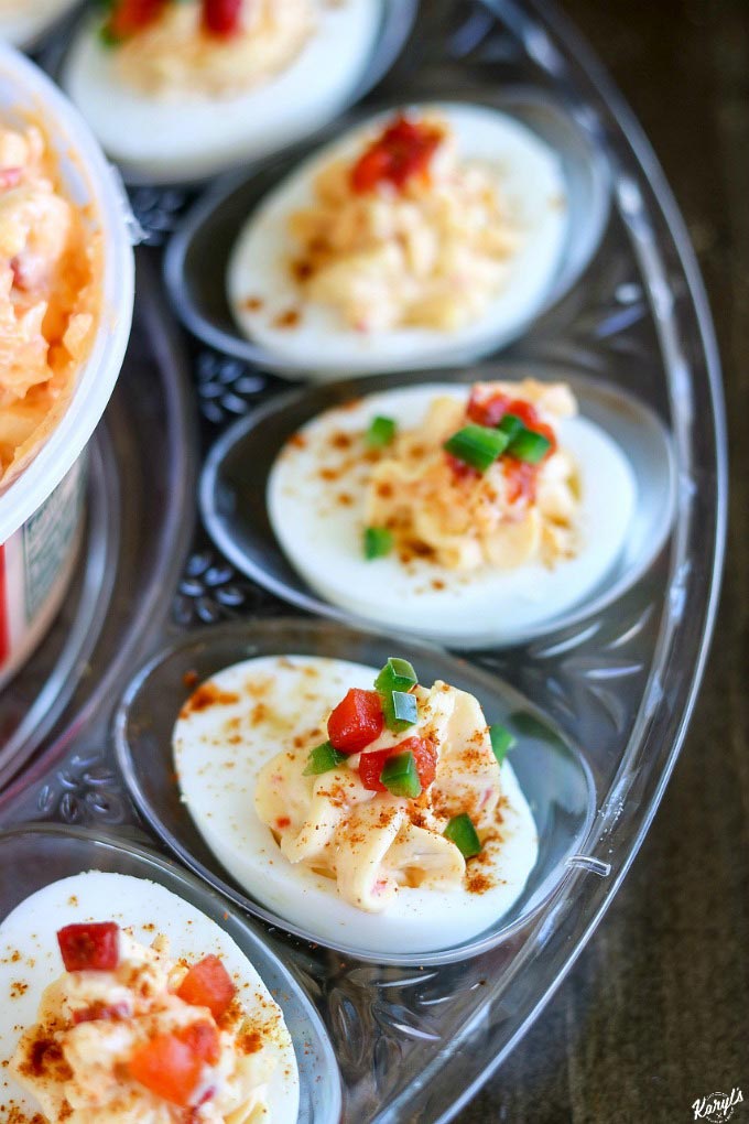 Pimiento Cheese Deviled Eggs will become your new favorite summer party snack! Price*s Pimiento Cheese Spread is a tradition worth sharing with your friends and loved ones, adding a wonderful new flavor dimension to the traditional deviled egg. Finish with diced pimiento peppers plus diced jalapenos for a delicious kick #Ad #pricestradition #pimientiocheesespread #pimientocheese #summerentertaining #deviledeggs 