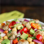 close up angled shot of finished Chicken Chickpea Salad in a white bowl with a green napkin