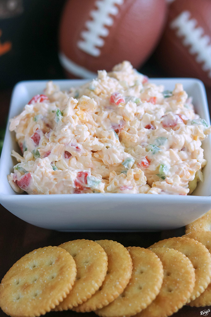 close up shot of finished pimiento cheese in white bowl with crackers in the front
