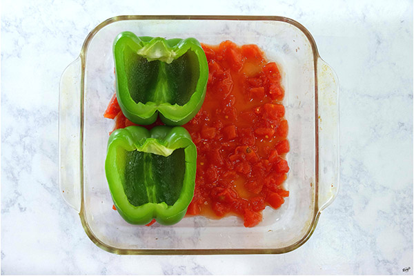 Process shot: tomatoes and 2 bell peppers in a glass baking dish