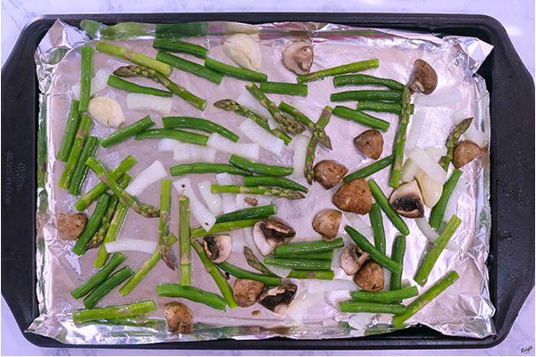 Process picture: overhead shot of raw vegetables on a baking sheet, ready to roast