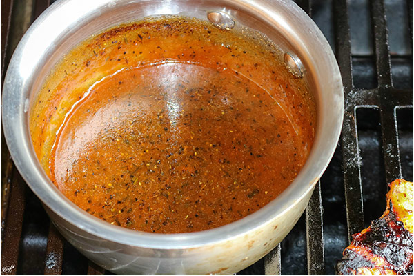 overhead process shot: marinade simmering in a saucepan on the grill