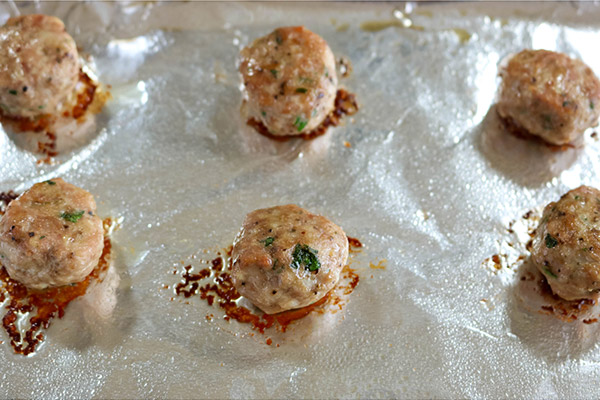 Process shot: cooked meatballs on baking sheet