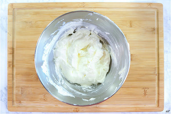 overhead process shot: cream cheese mixture in a large metal mixing bowl