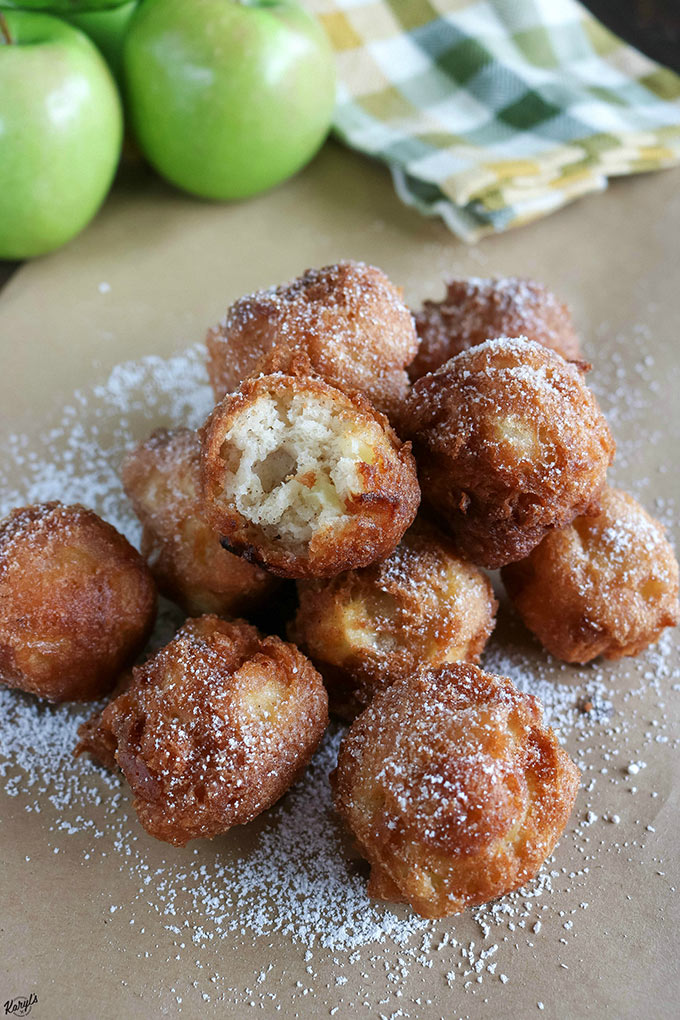 close up shot of a stack of finished Bourbon Apple Fritters with one fritter with a bite taken out